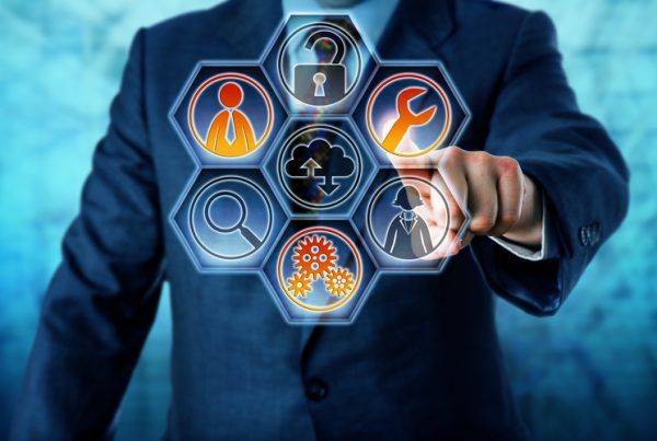 A person in a suit touches a transparent touchscreen with hexagonal icons representing business concepts, including Threat Prevention, security, cloud computing, tools, gears, search, people, and Managed IT Services.