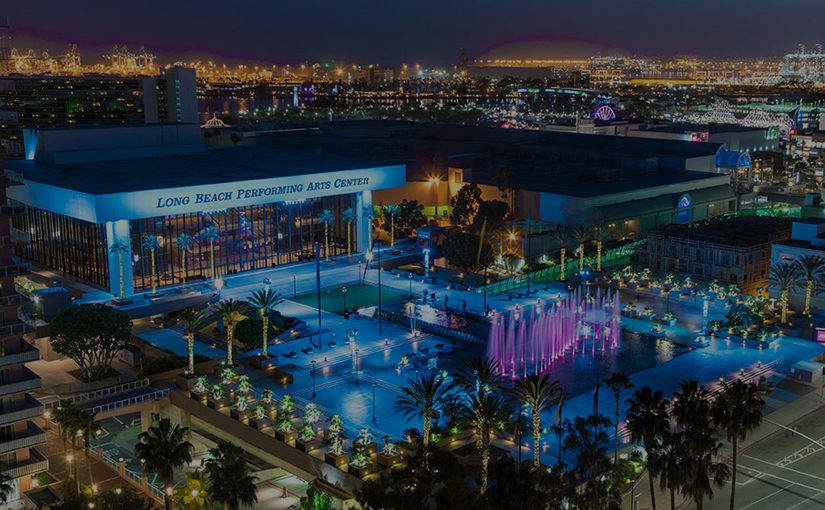 A nighttime view of the Long Beach Performing Arts Center during the CITE Annual Conference, with colorful illuminated fountains, city lights in the background, and conference booths nestled among palm trees and modern buildings.