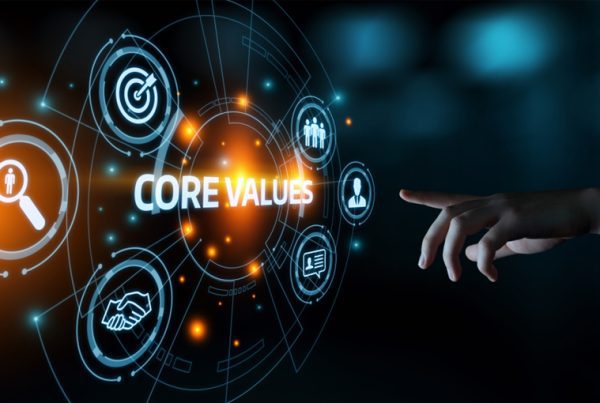 A hand points toward a glowing digital interface displaying the words CORE VALUES, highlighting GoodSuite’s commitment to goals, teamwork, trust, and search, all set against a dark, futuristic background.