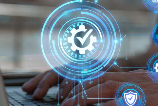 Hands typing on a laptop keyboard with digital icons overlaid, including a checkmark in a gear, graphs, and security symbols, representing Managed IT Services focused on technology, security, and effective data management.