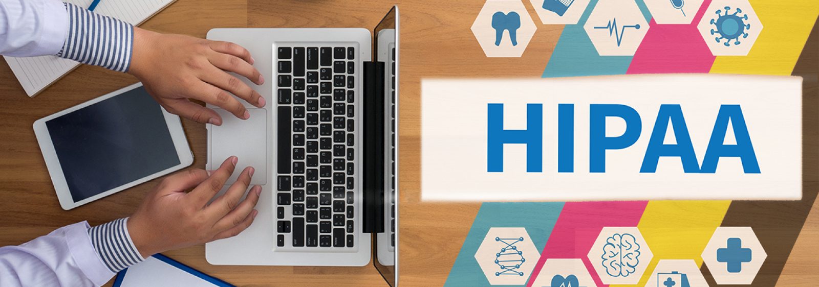 A person typing on a laptop next to a tablet, with the word HIPAA compliance displayed beside medical icons such as a heart, tooth, and stethoscope on a colorful background.