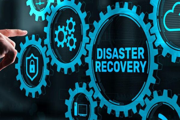 A person’s hand points at interconnected blue gears on a screen, with the central gear labeled Disaster Recovery, highlighting backup solutions and data security icons—essential tools for small businesses managing digital technology.