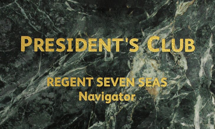 Presidents-Club Gold text on a green marble background reads PRESIDENTS CLUB REGENT SEVEN SEAS Navigator, highlighting an exclusive experience with the elegance of GoodSuite.