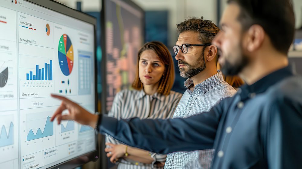 Business team reviewing cybersecurity training metrics and analytics dashboard during a security performance assessment meeting.