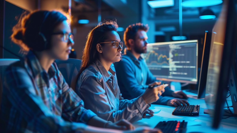 Employees participating in cybersecurity awareness training on computer screens.